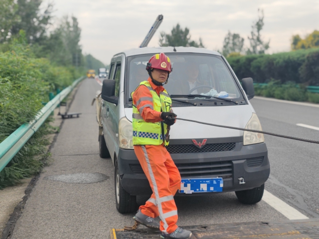 亳州中心阜陽段上行K376施救員徐建才調(diào)整拖車鋼絲繩，開展救援行動。.jpg